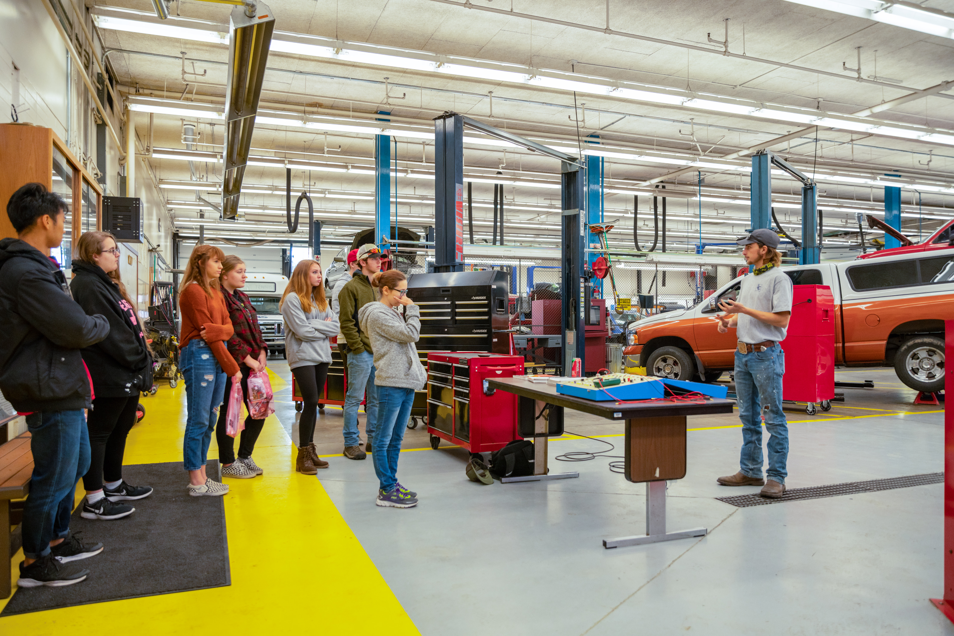 CTE student talking with tour group in the auto shop