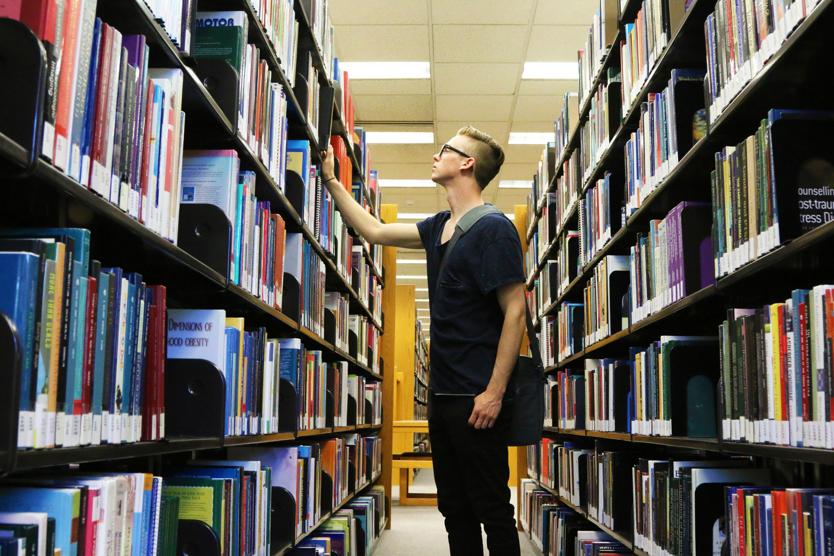 Student looking at books in the library