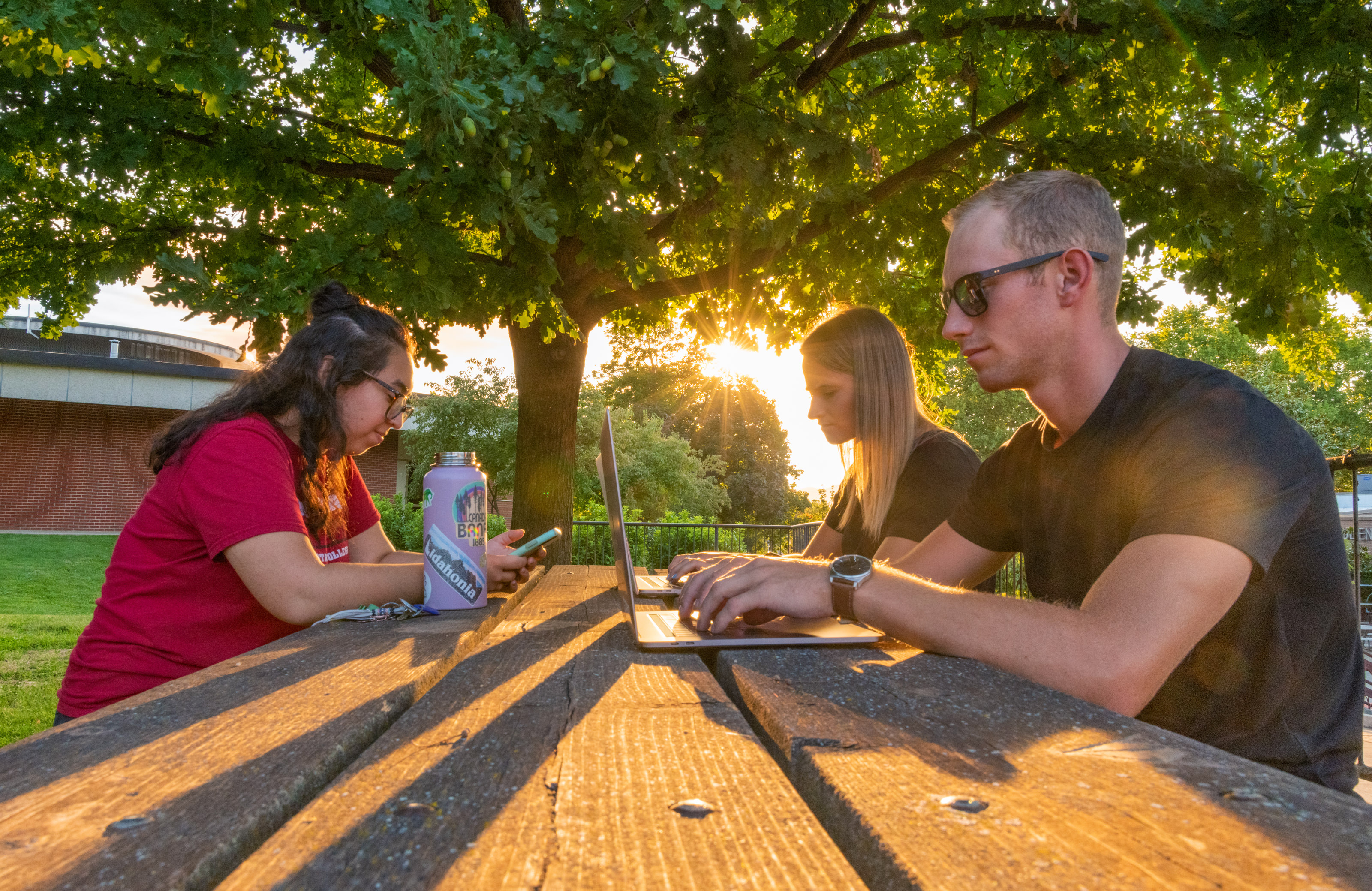 Students writing at a picnic table