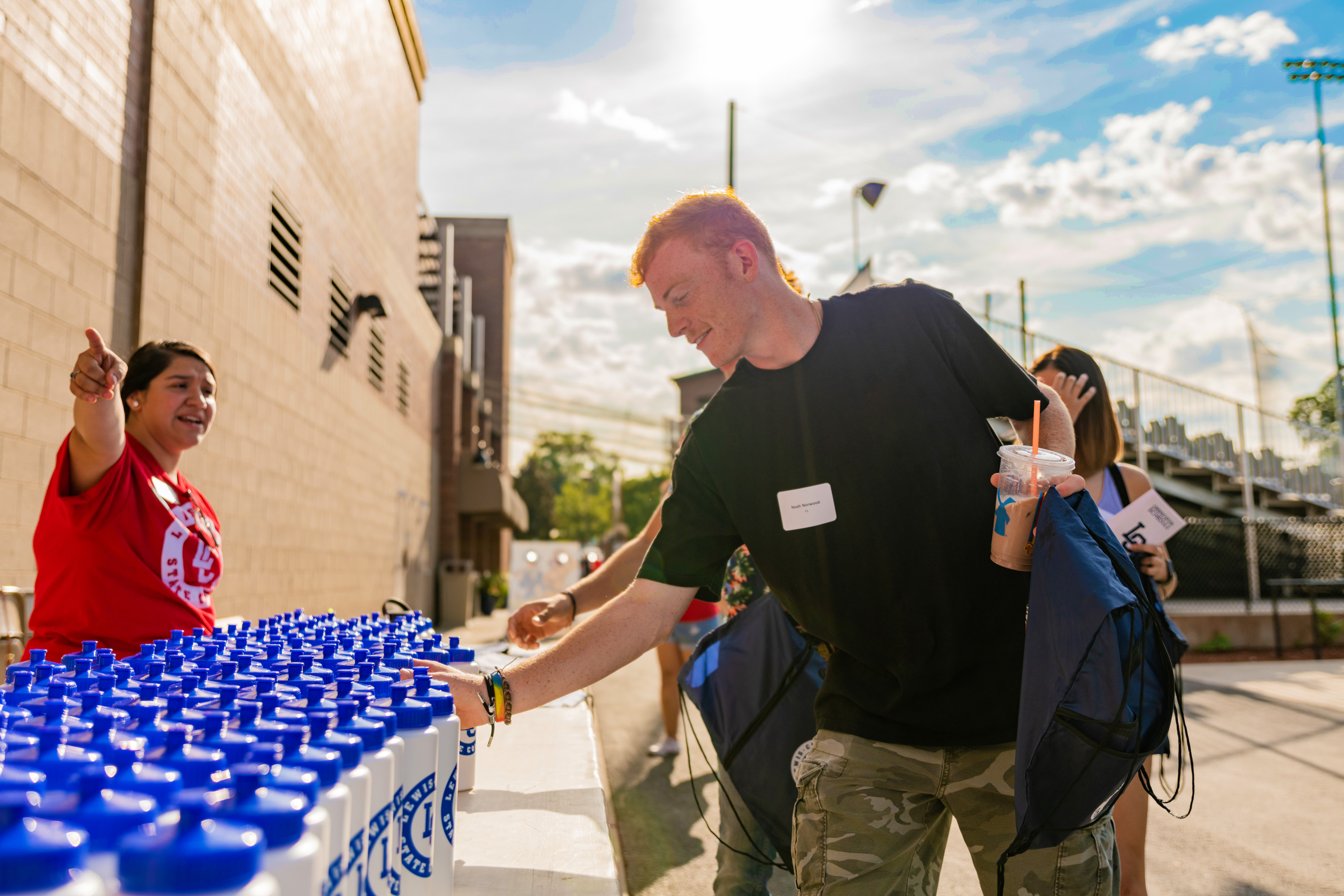 Male student picking up a waterbottle