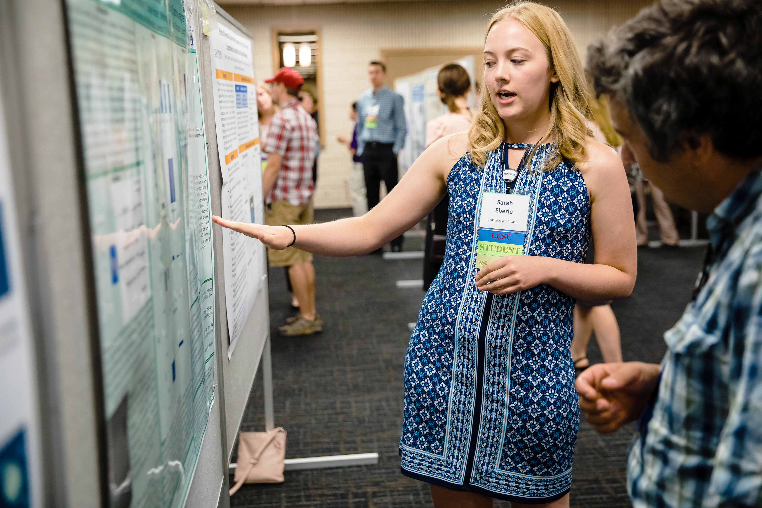 Female student explaining her post exhibit