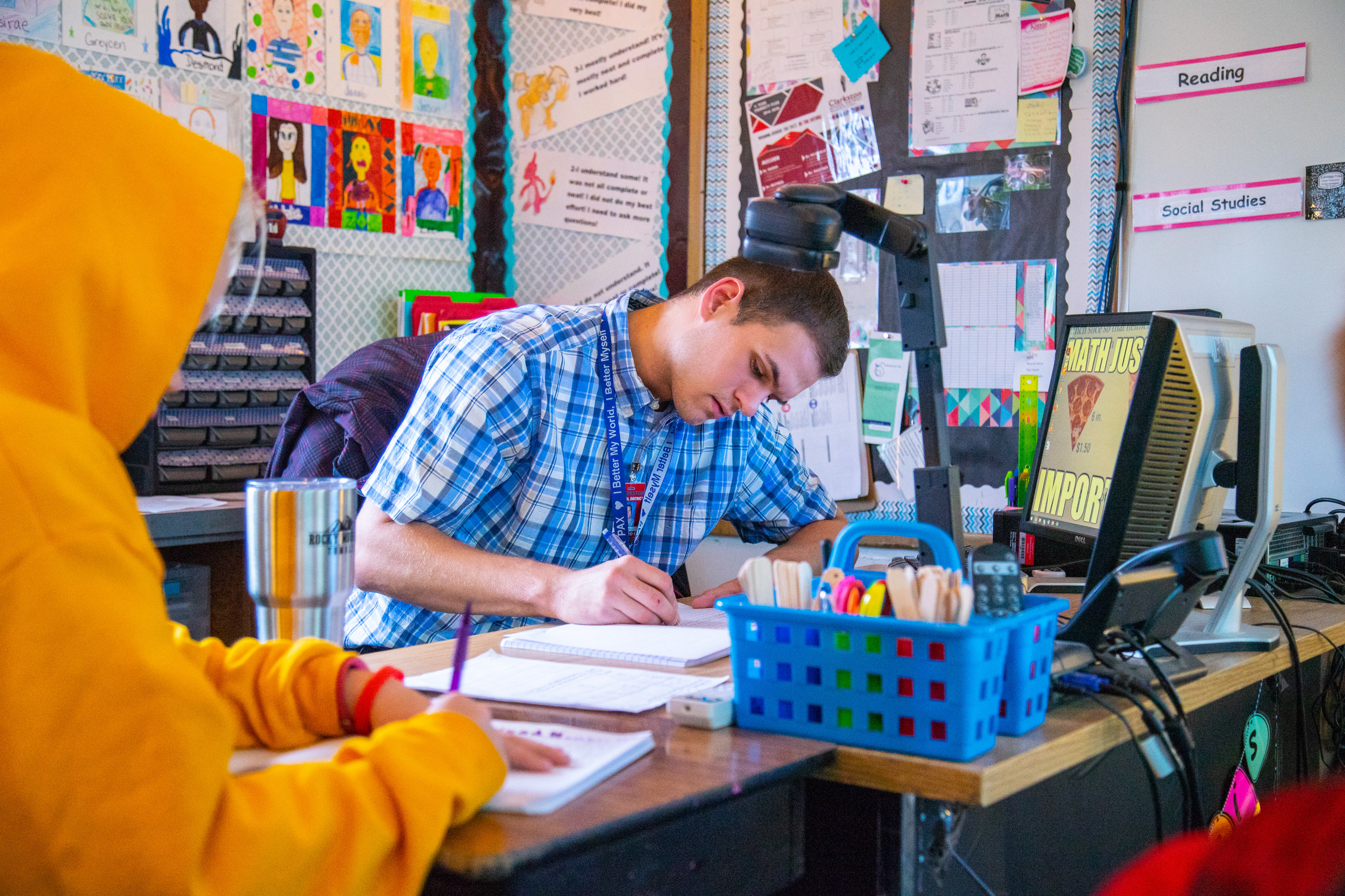 Male teaching working at desk at elementary school