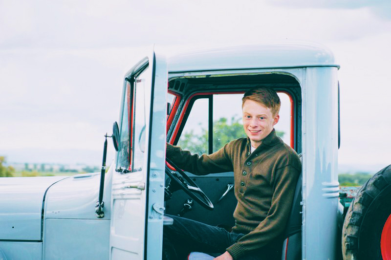 A young male entrepreneur seated in a truck