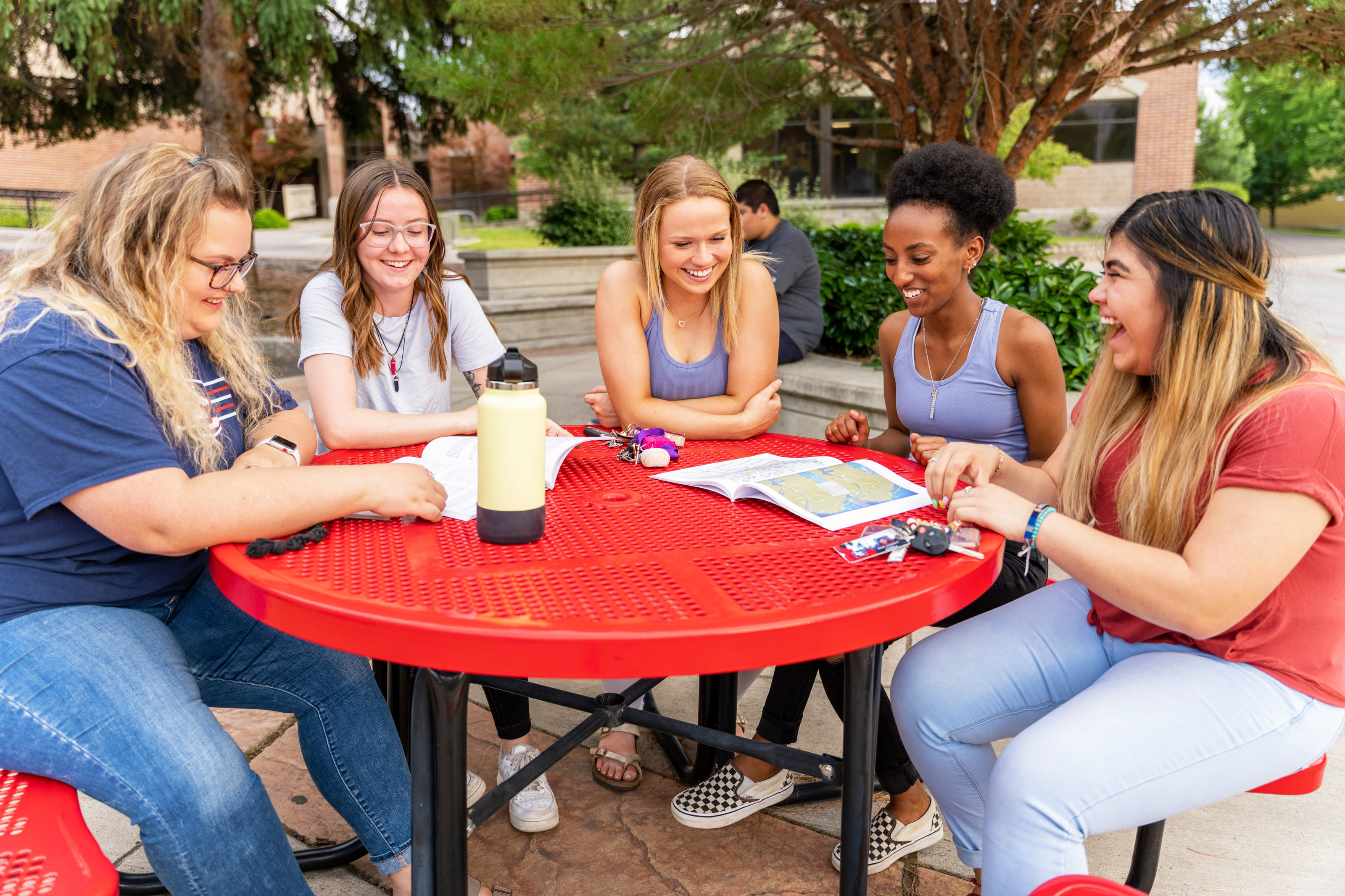 Students sitting at a table on campus talking